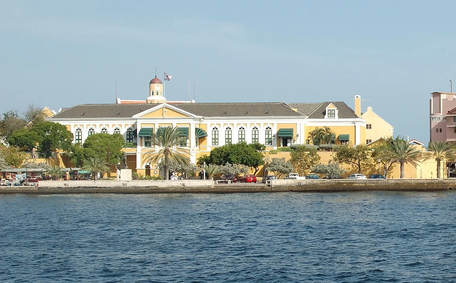 Fort Amsterdam in Willemstad met geel-oranje gevels, kanonnen aan de waterkant van de Sint Annabaai