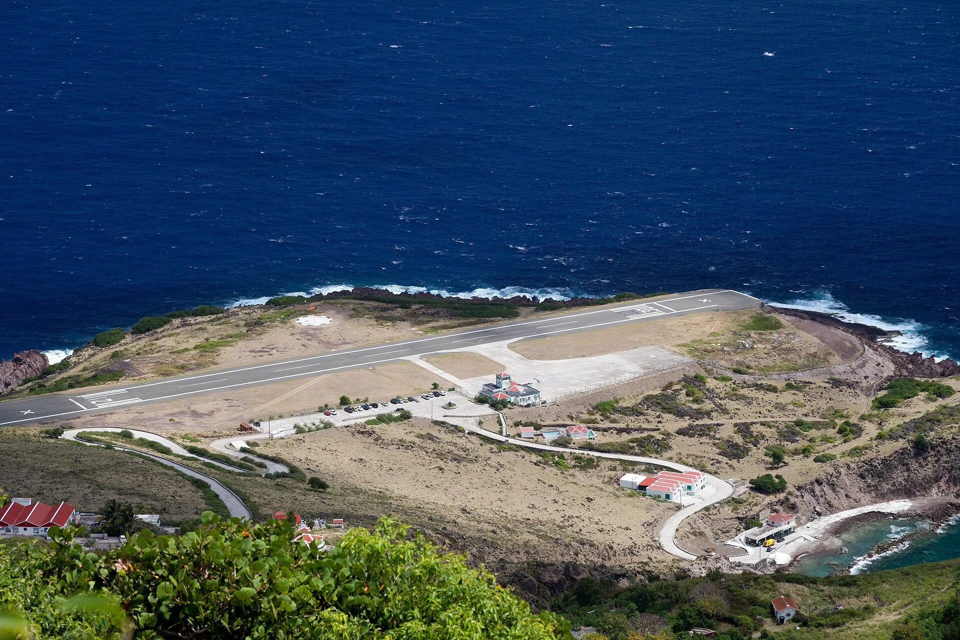 Vliegtuig op de korte startbaan van Saba Airport omgeven door kliffen
