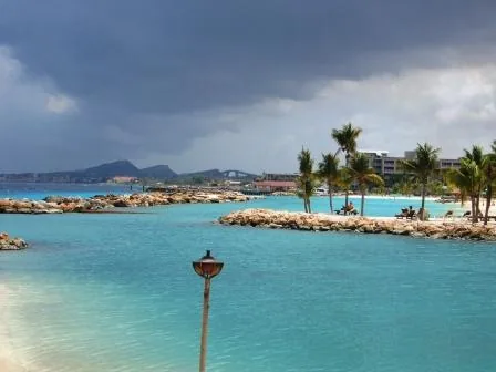 Turquoise lagune met palmbomen en rotsformaties langs de zuidoostkust van Curaçao bij een resortstrand