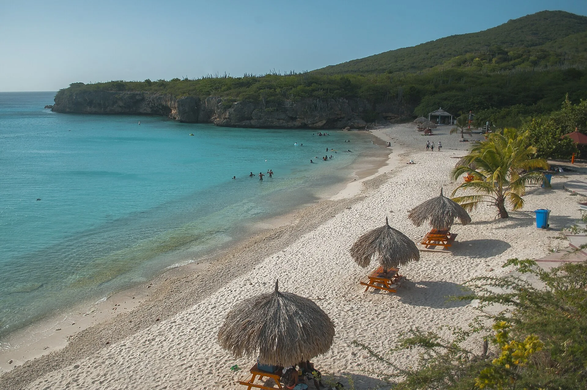 Grote Knip baai op Curaçao met turquoise water, witte zandstrook en groene kliffen aan weerszijden